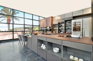 A modern, modular Noblessa kitchen. That experiments with contrasting colors in the kitchen. Matte grey cabinets with warmed toned wood countertops and upper cabinets